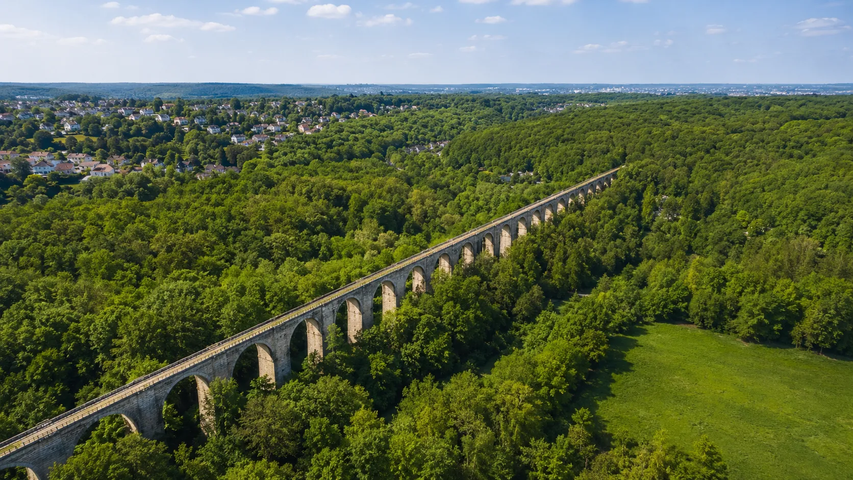 Aqueduc de Buc traversant la forêt des Yvelines, village résidentiel en arrière-plan, marché immobilier 2026
